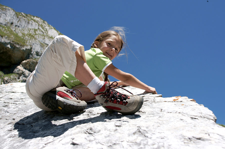 Mädchen klettert an einem Felsen
