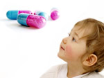 Kind schaut auf Tabletten